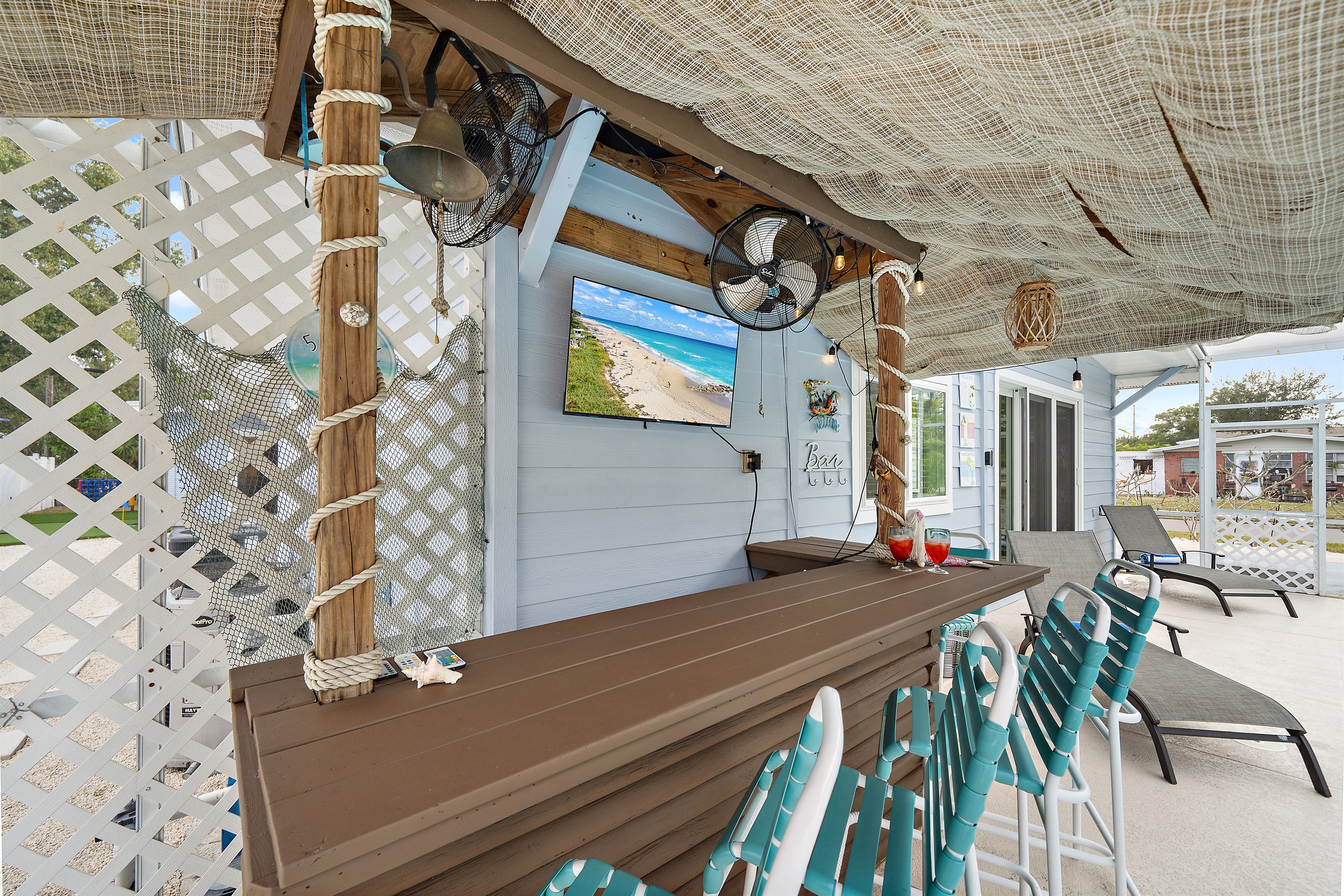 🍸 Sip, sit, and relax at the tiki bar featuring a 40" TV and five comfy bar stools.