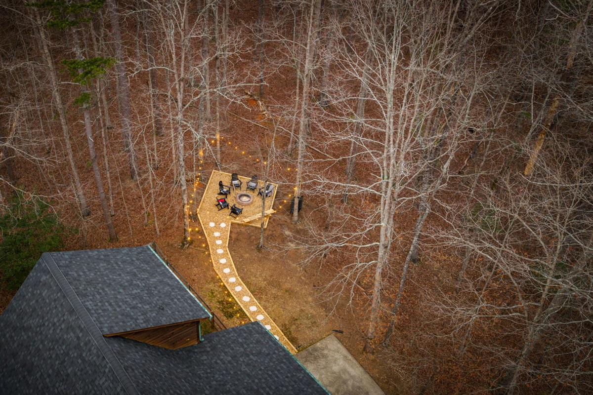 This stunning aerial view of the fire pit, captured by drone, showcases the layout of the outdoor space from above.