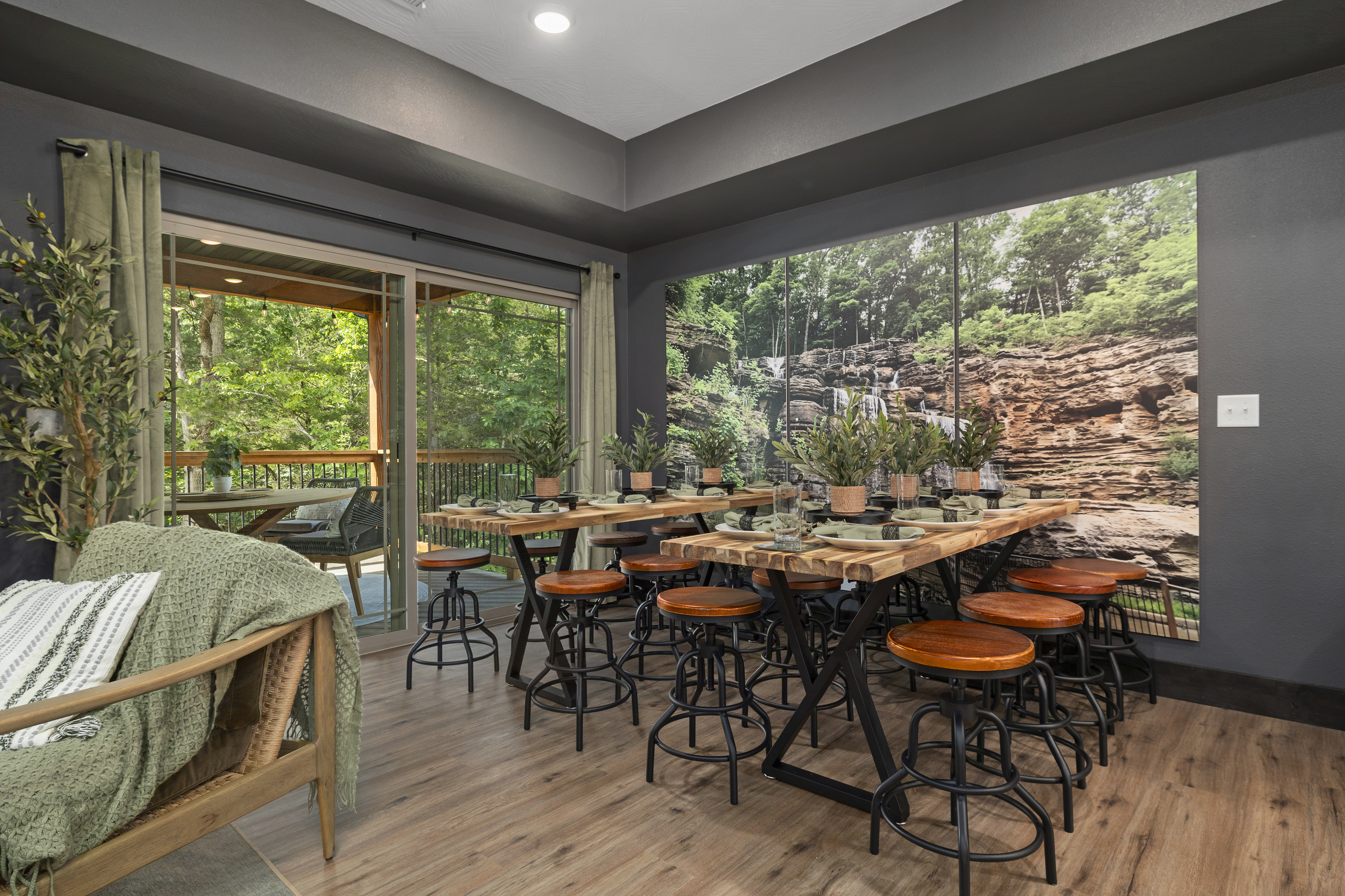 Counter-height dining with tall windows and green woods just outside.