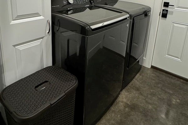 Laundry room with washer, dryer, including laundry soap, and cleaning supplies.