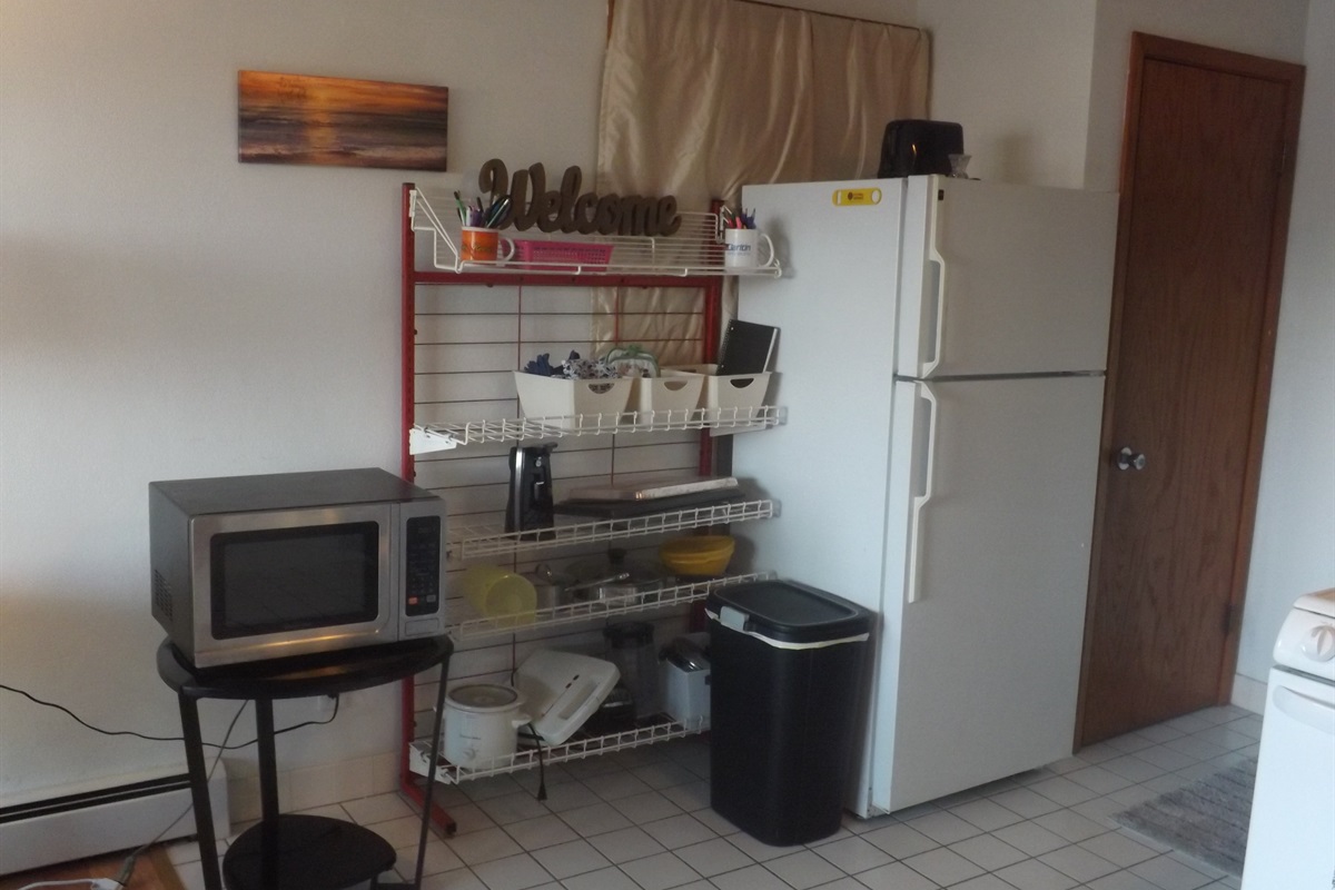 Full kitchen with refrigerator, stove, microwave, coffee makers, and most essentials
