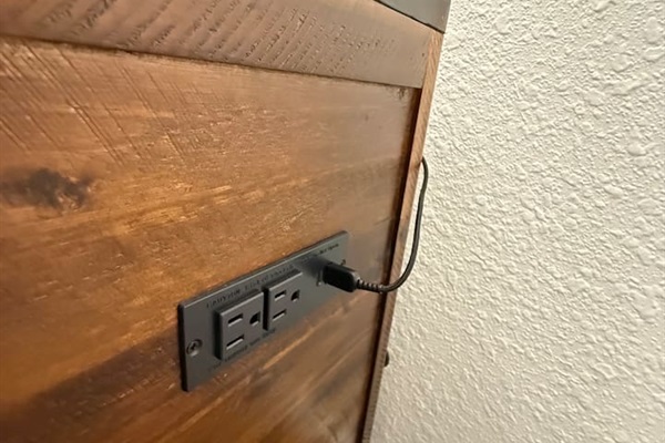 Nightstands with electrical outlets and USB outlets on either side of the bed. 