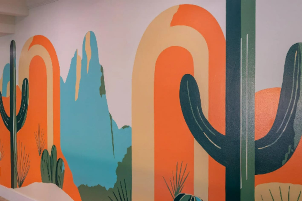 A bold, hand-painted desert mural adds color and personality to the space, a fun backdrop for photos.