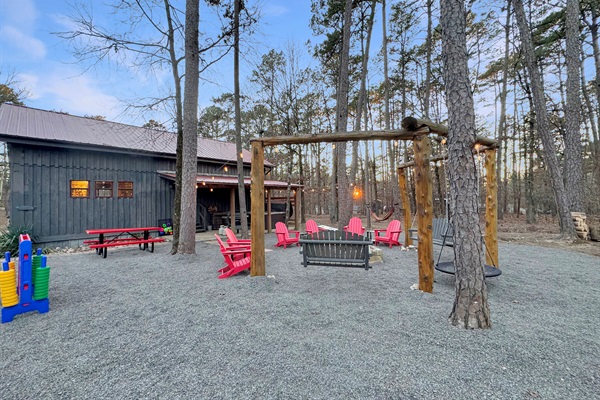 Back yard firepit, swings, playset, Connect 4, hammock, horseshoes, and grill.