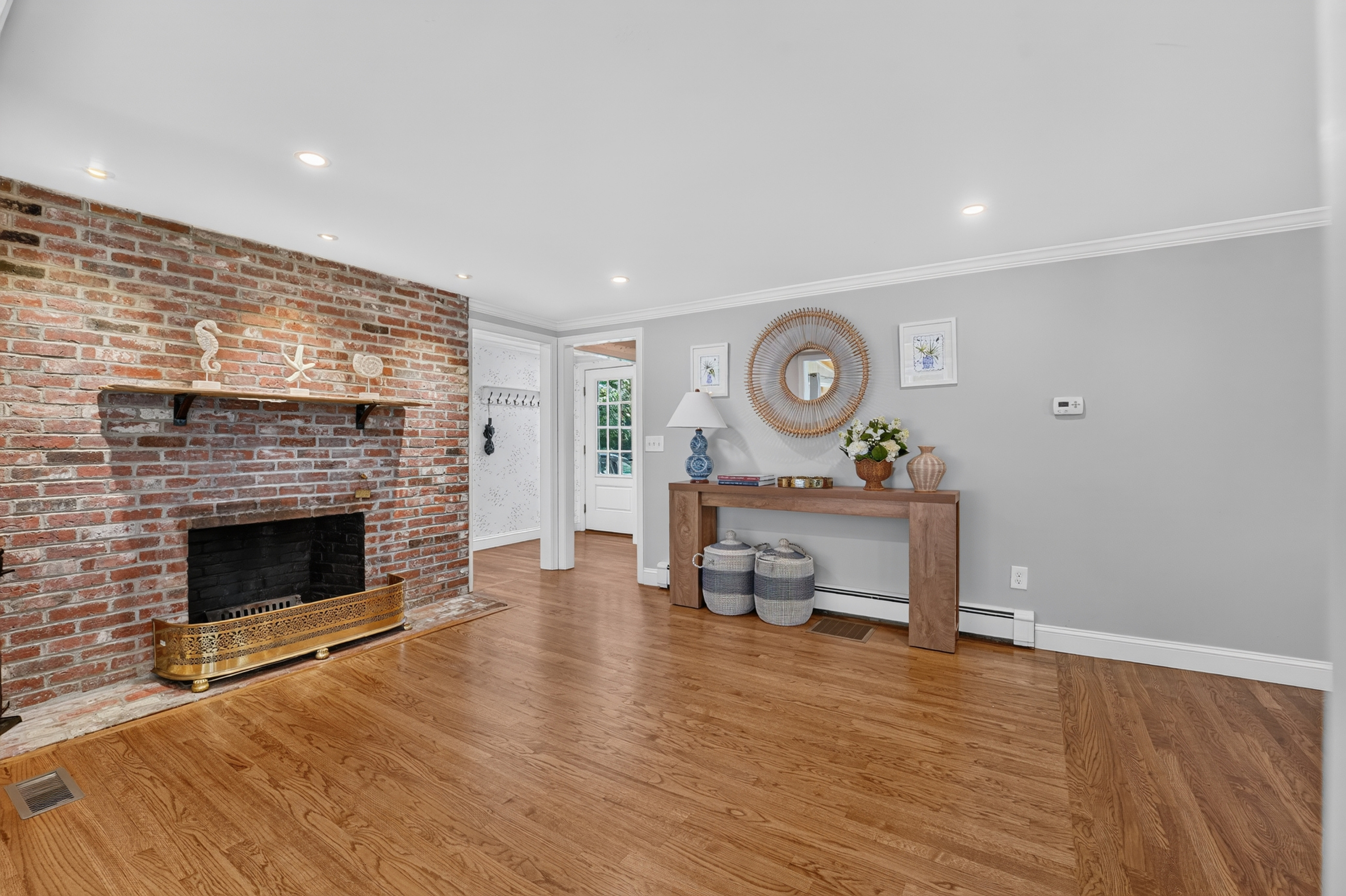 Additional gathering space with a charming brick fireplace and hardwood floors.