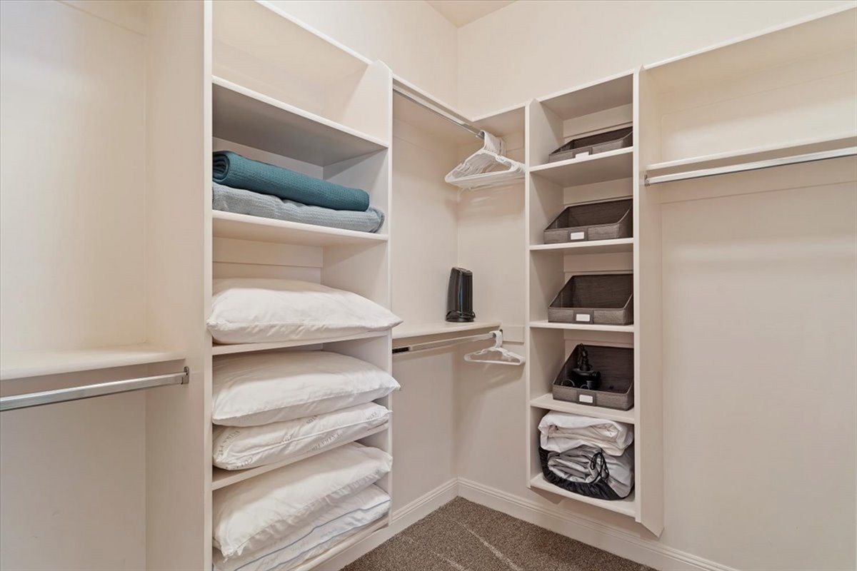 An expansive walk-in closet with custom shelving, offering ample space and organization for a seamless, extended stay.