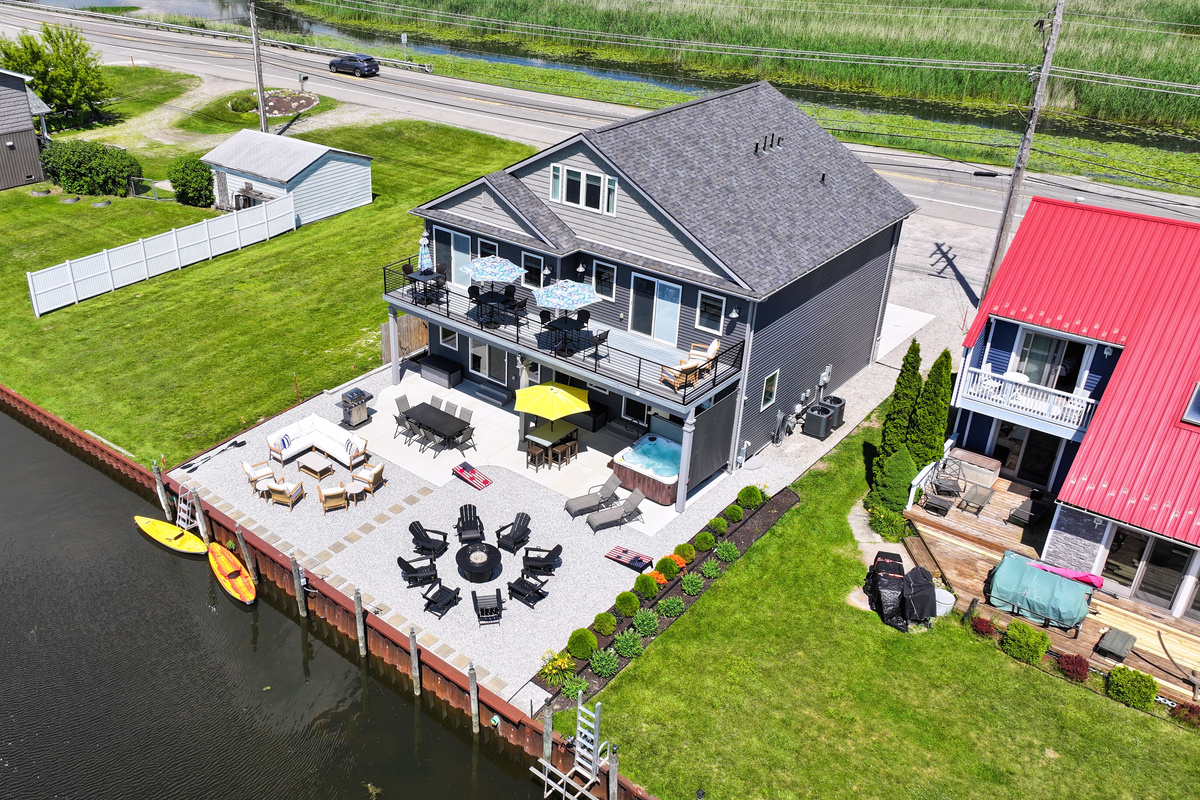 This private canal-front getaway features expansive outdoor living spaces, a private dock, kayaks, hot tub, fire table, and easy access to the lake's popular sandy swimming area—all designed for unforgettable waterfront memories.