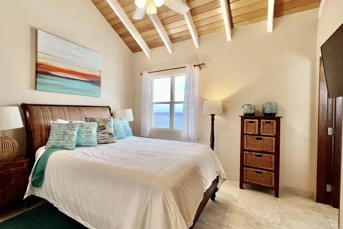 Oceanview bedroom with vaulted ceilings—wake up to blue water and island breezes.