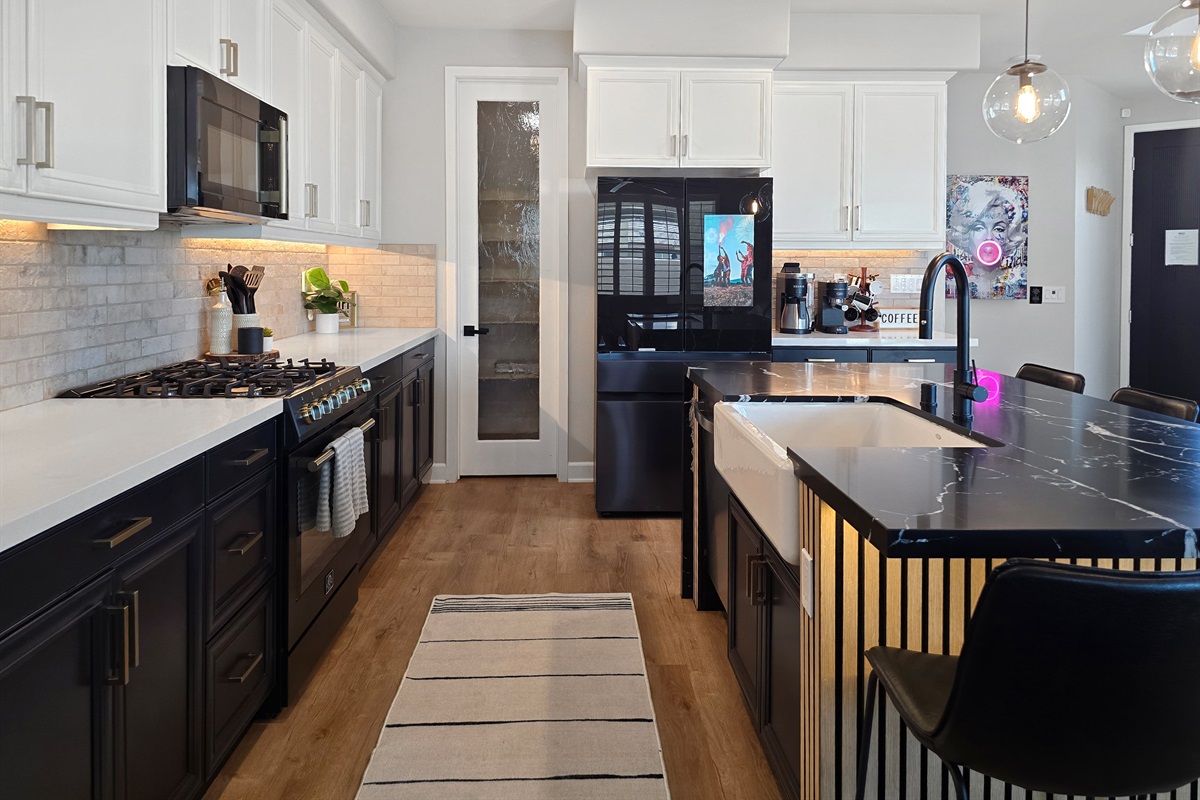 The kitchen features tuxedo style cabinets with a white farm sink.