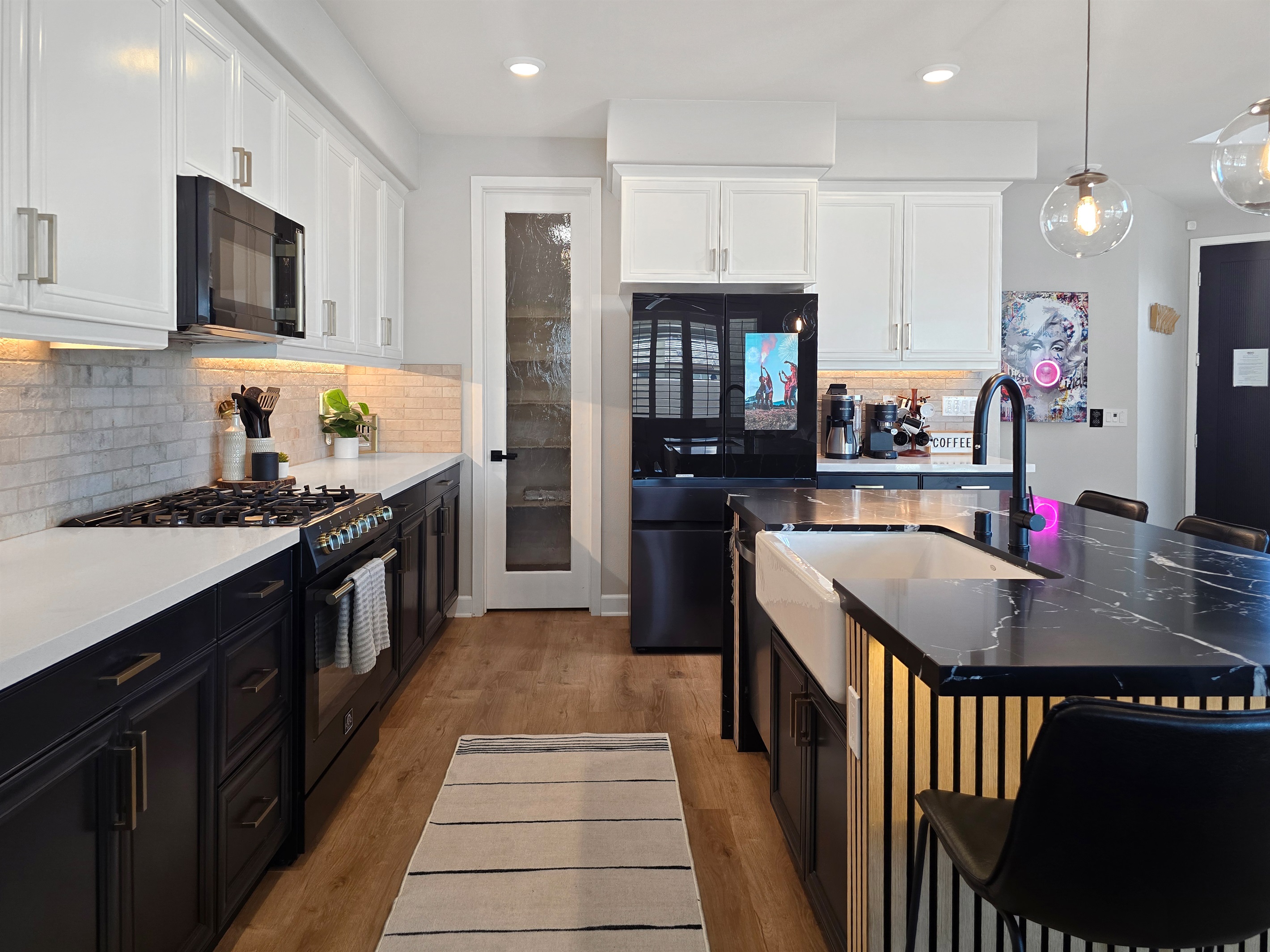 The kitchen features tuxedo style cabinets with a white farm sink.