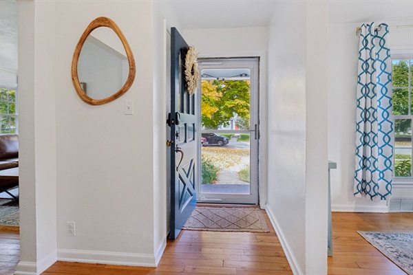 Step inside—our South Bend guest retreat entry features a warm-toned mirror with organic charm and a welcoming view of the beautiful front yard. A cozy first impression near Notre Dame.