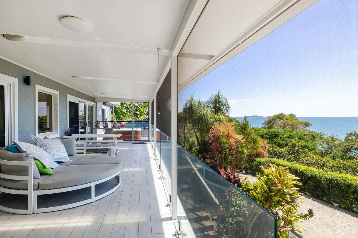 Ocean views stretch beyond the garden from this generous deck, creating one of the standout outdoor spaces at Nicos Butterfly Beach House.