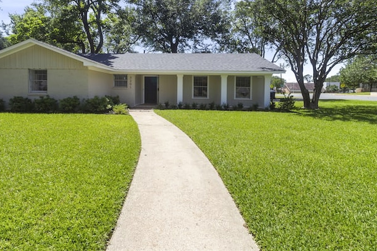 Welcoming front exterior with spacious yard and charming curb appeal.