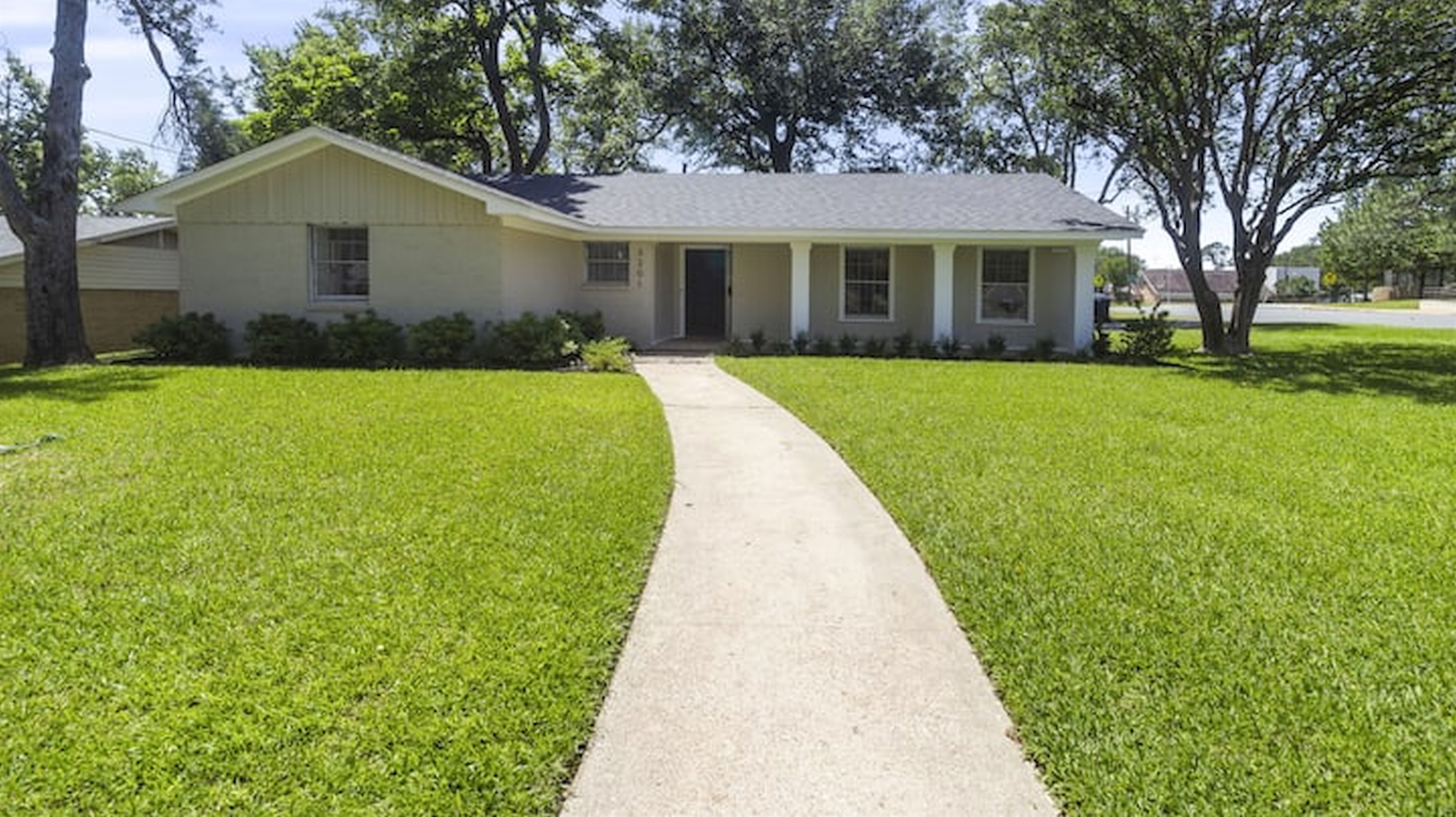 Welcoming front exterior with spacious yard and charming curb appeal.
