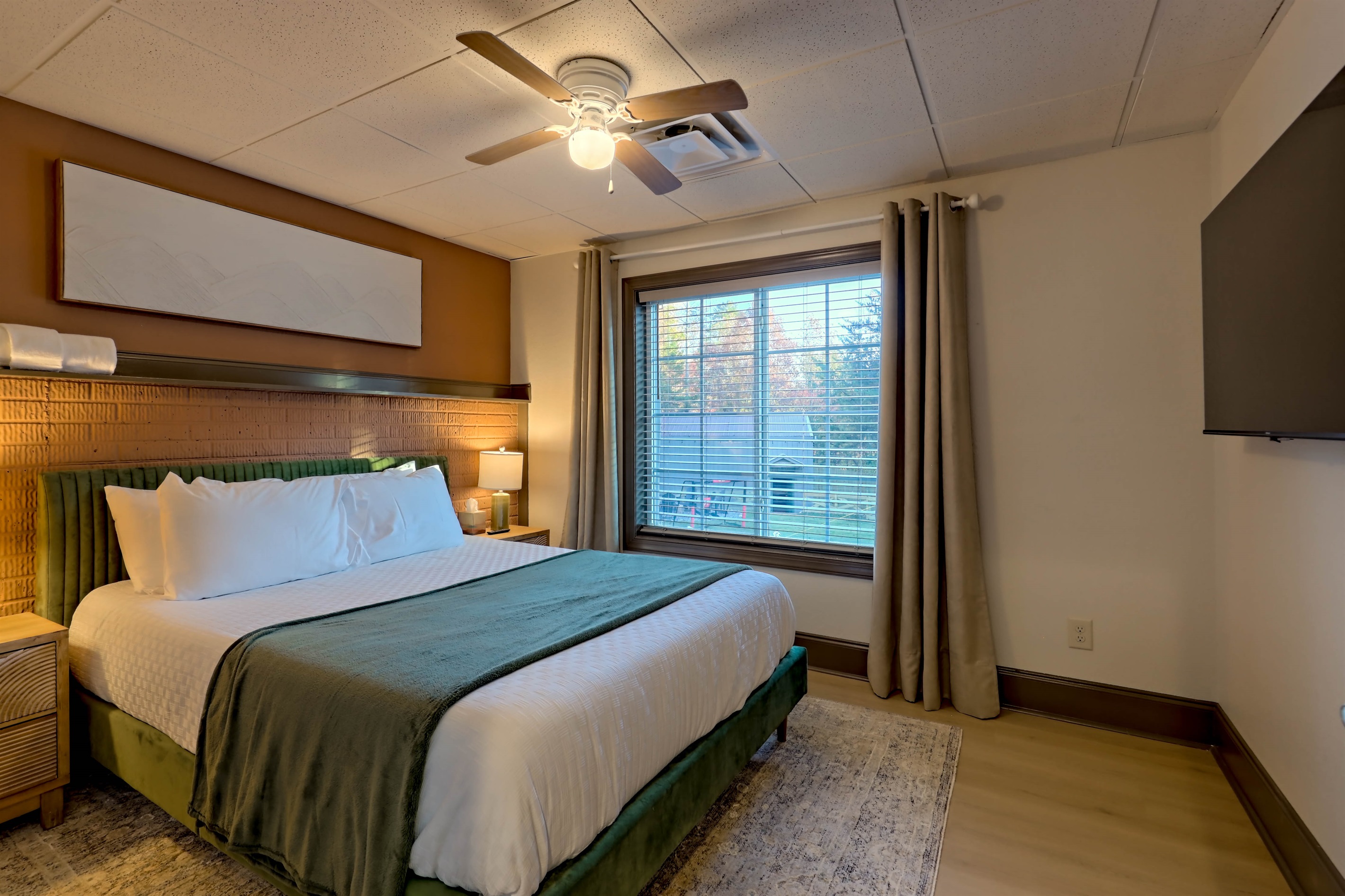 Comfortable queen room with stylish décor and a TV.