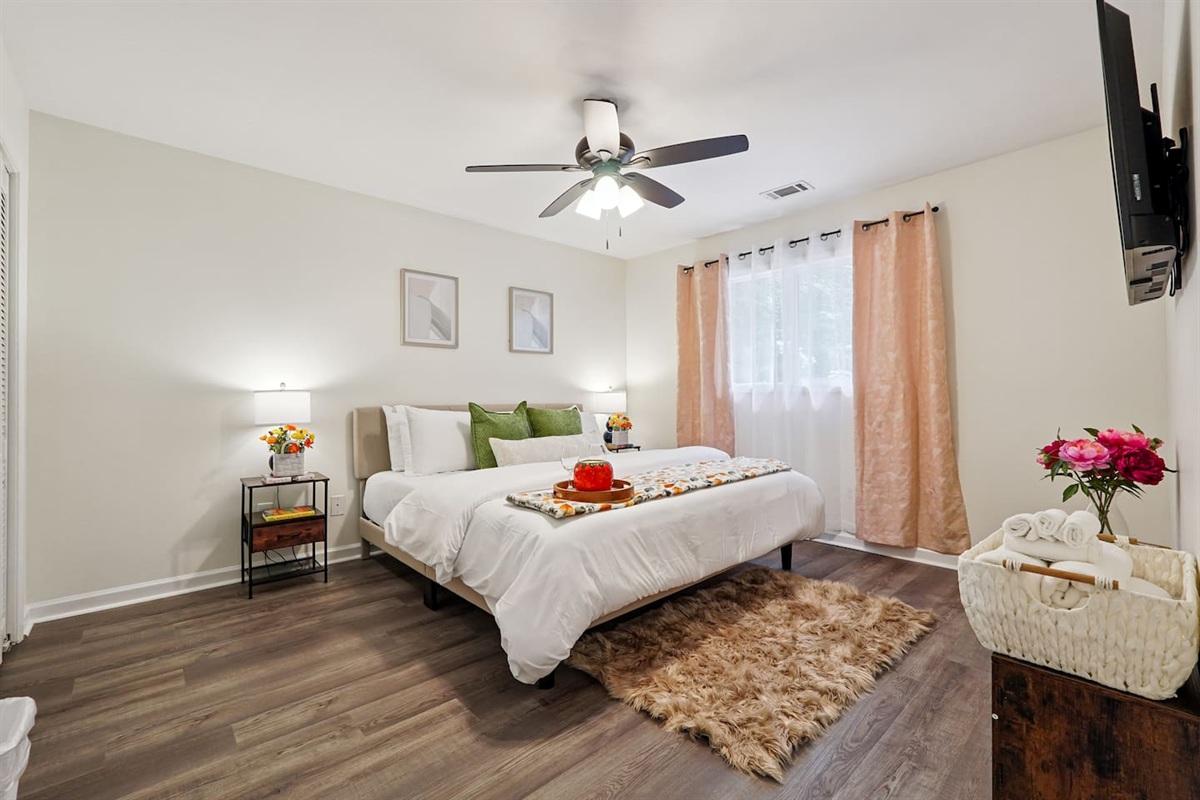 Master bedroom featuring a comfortable king bed and an Amazon Fire-powered Smart TV. The shared bathroom is conveniently right next door. This room includes 2 full-body towels, 2 washcloths, and 2 hand towels for your stay.