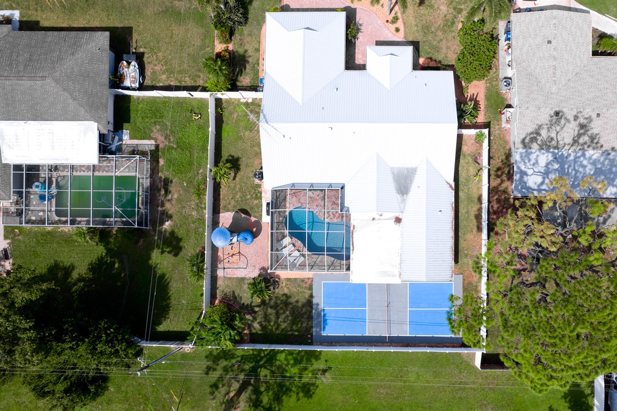 See your entire vacation oasis from above — a stunning home surrounded by endless amenities: poolside lounging, outdoor playtime, and pickleball matches waiting to happen.