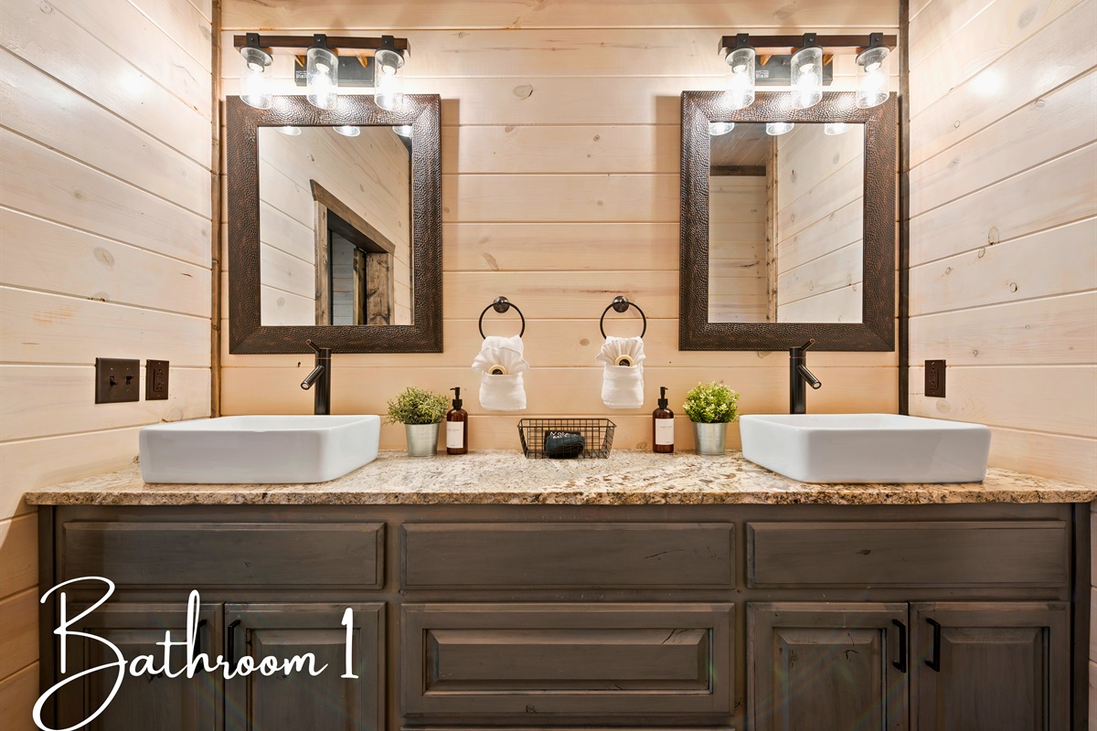 The bathroom showcases a double vanity with modern fixtures and mirrors, set against a backdrop of light wood walls.
