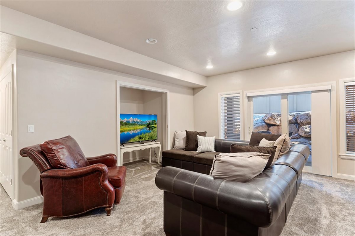 Another view of the lower-level lounge highlights its generous layout, creating a comfortable space for movie nights and downtime.