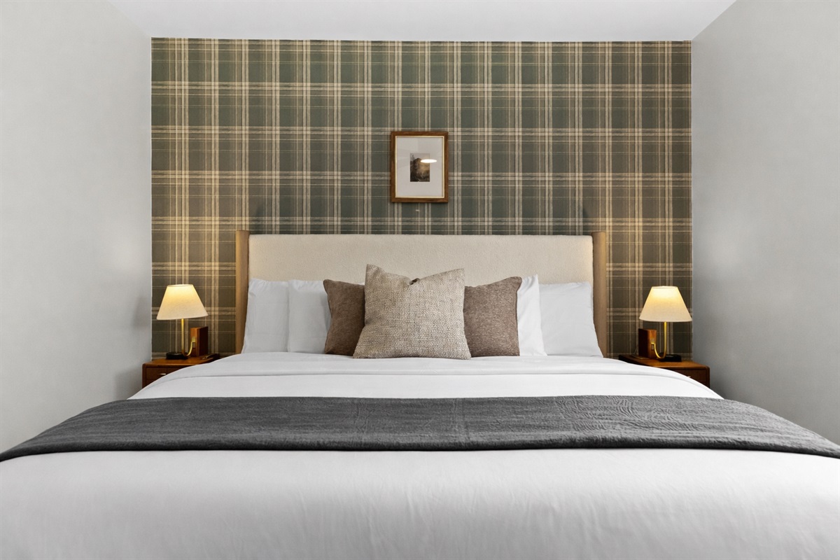 Cozy, well-appointed bedroom with a plush bed, soft lighting, and stylish accent wall—perfect for relaxing, recharging, and enjoying a peaceful night’s sleep.