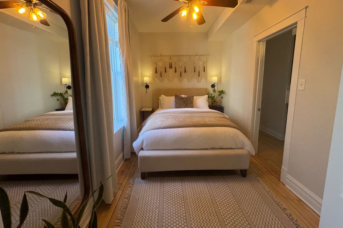 Peaceful bedroom with plush bedding and warm lighting.