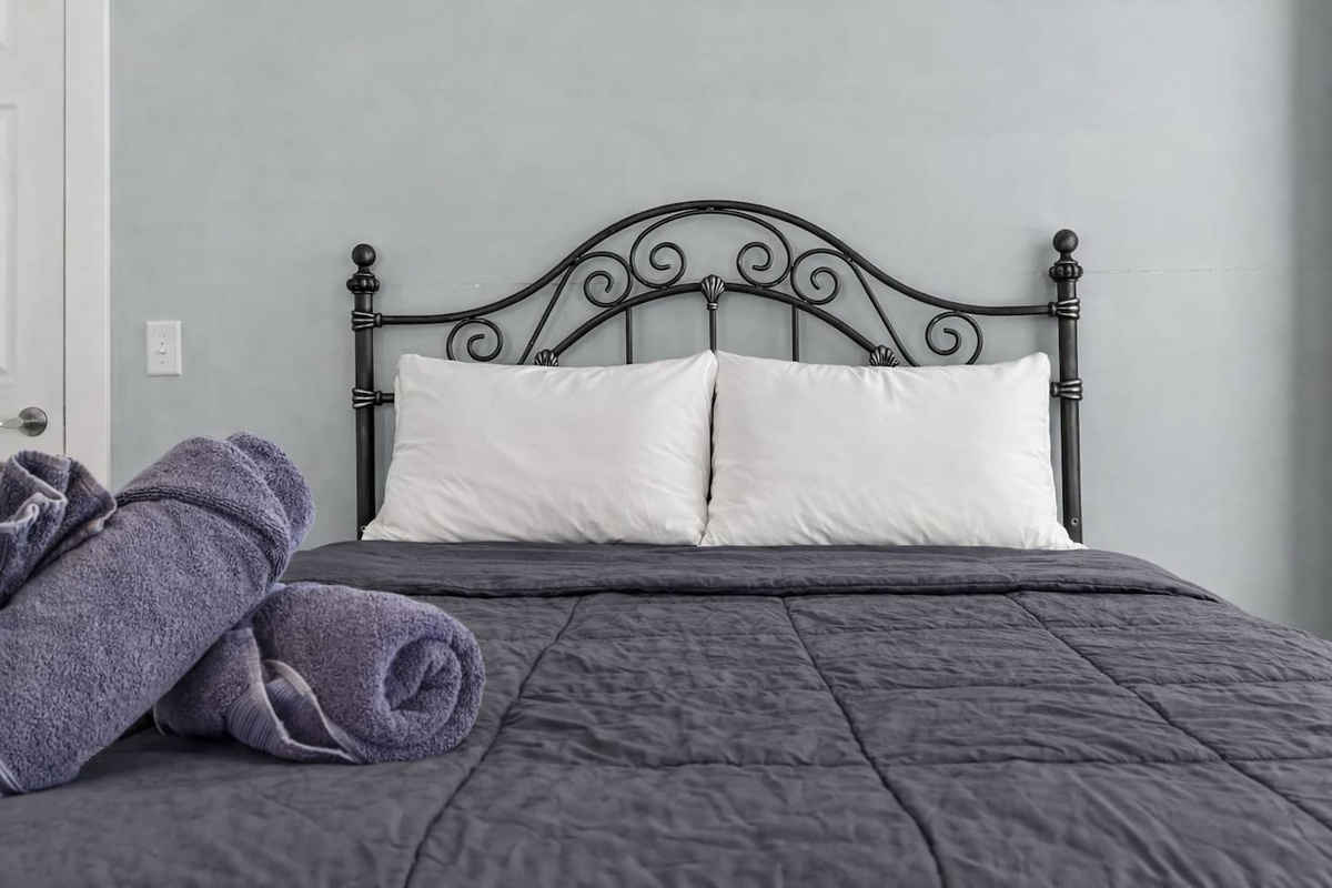 Centered bed view with neatly folded towels, creating a calm and restful sleeping atmosphere.