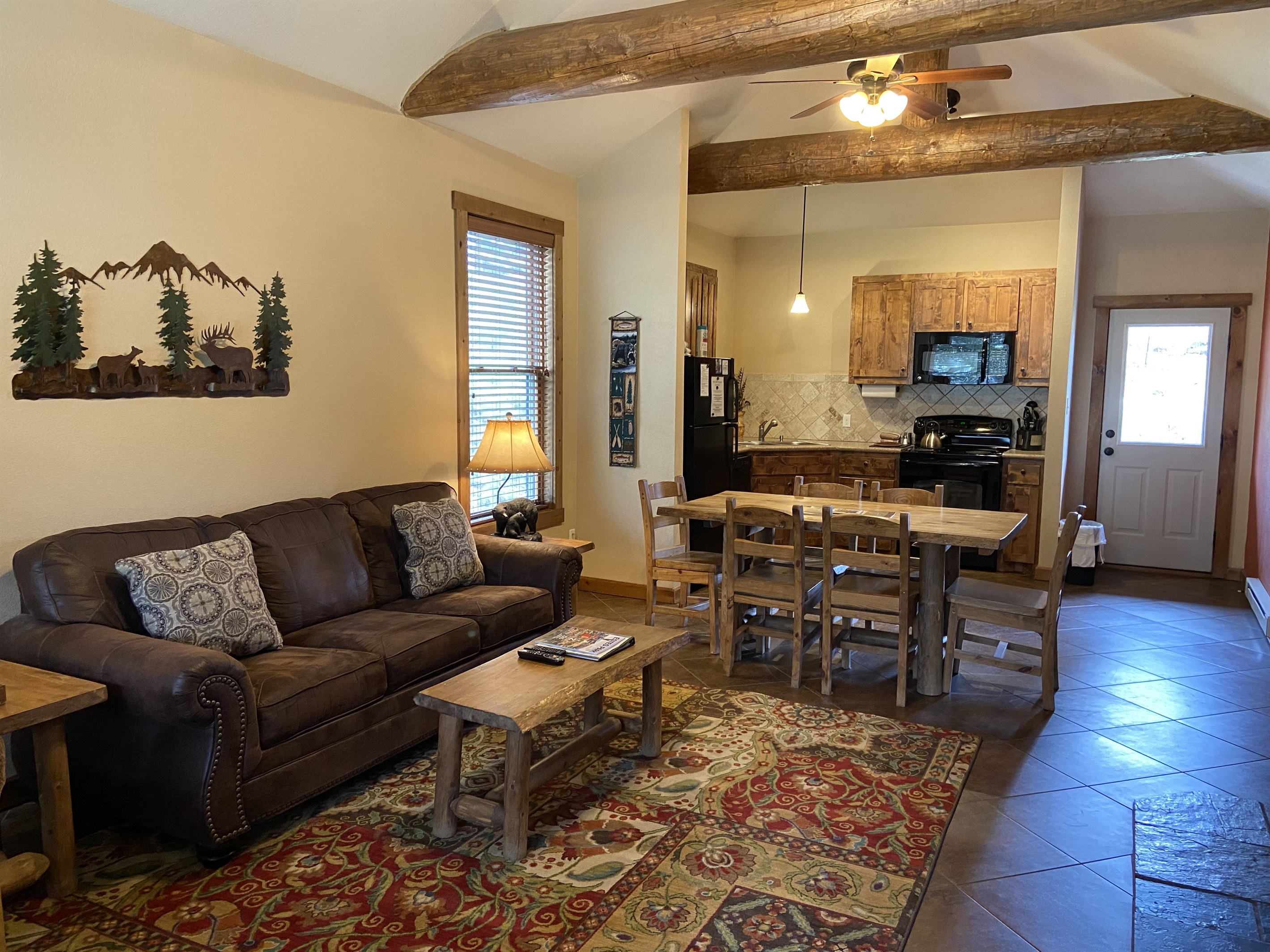 Living room with vaulted ceilings and log accents.