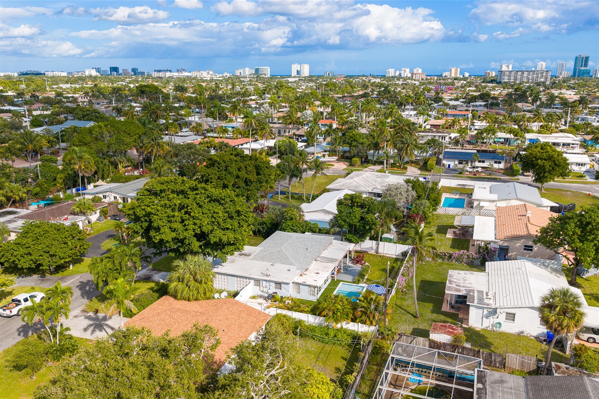 Soaring aerial perspectives highlight the home’s tranquil Pompano Beach neighborhood, private backyard oasis, covered carport, and extended driveway with space for 3 cars.