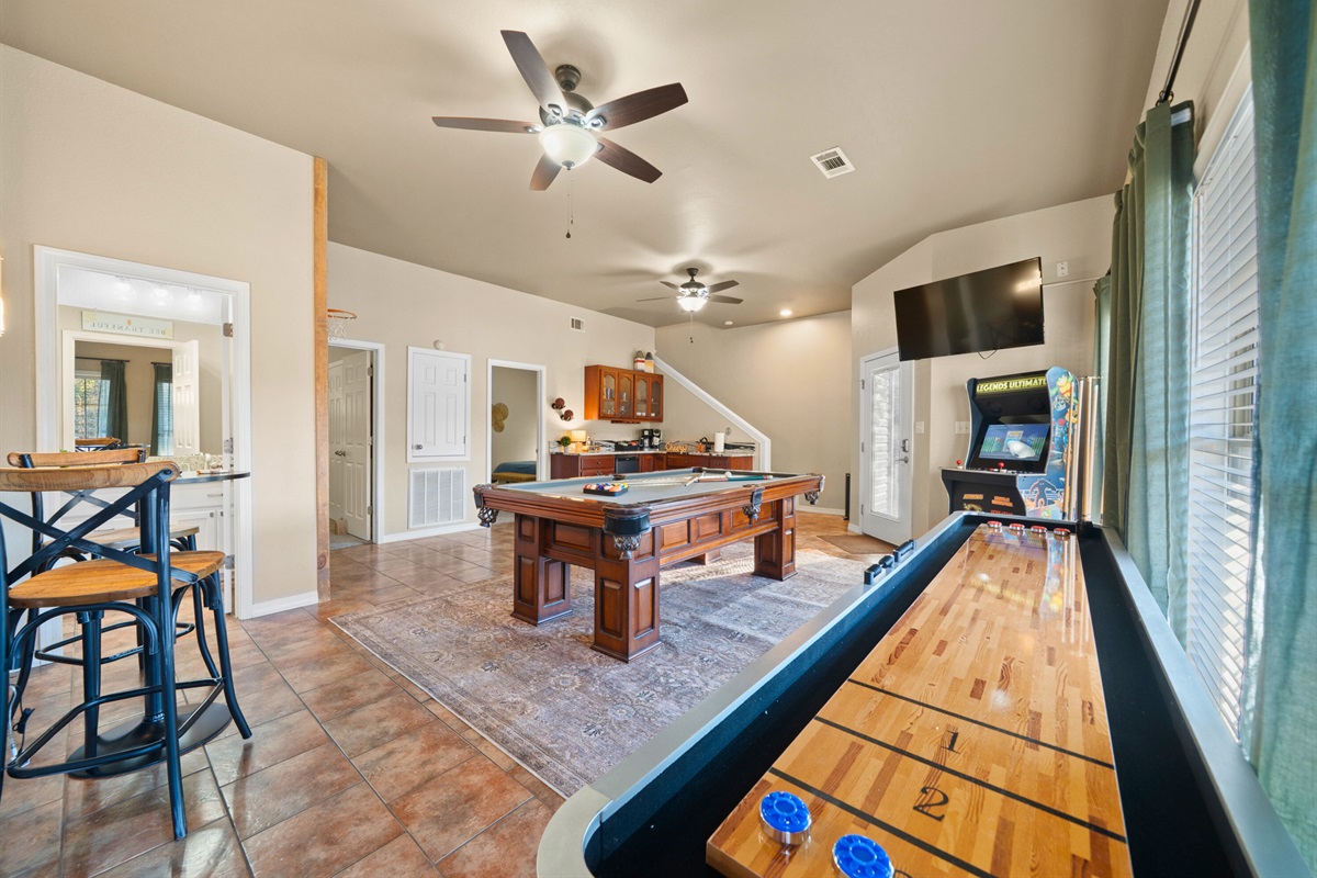 Shuffleboard and additional seating round out this fun-filled game room, making it a go-to spot for evening hangouts.