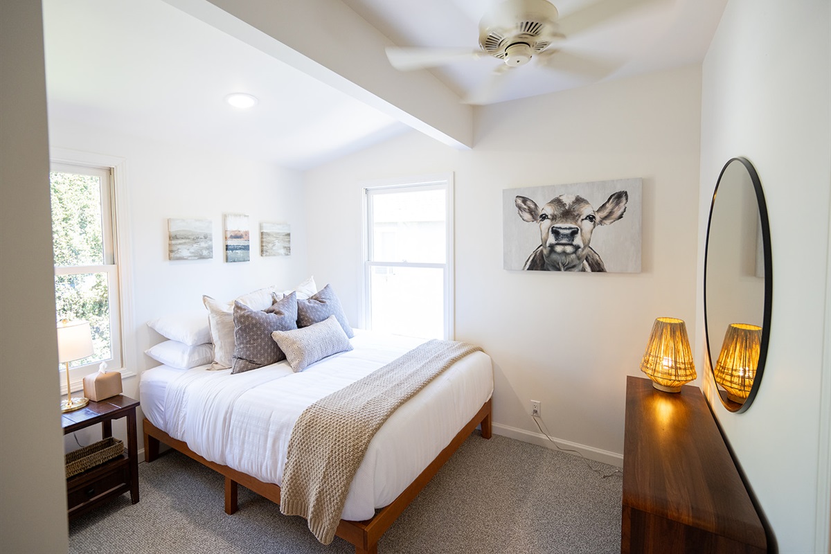 Comfortable bedroom featuring a queen bed, soft linens, and a calm setting for a restful night’s sleep