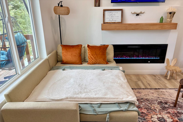 Wake up by the fireplace with forest views and coffee in bed — our sleeper sofa is made for slow mornings