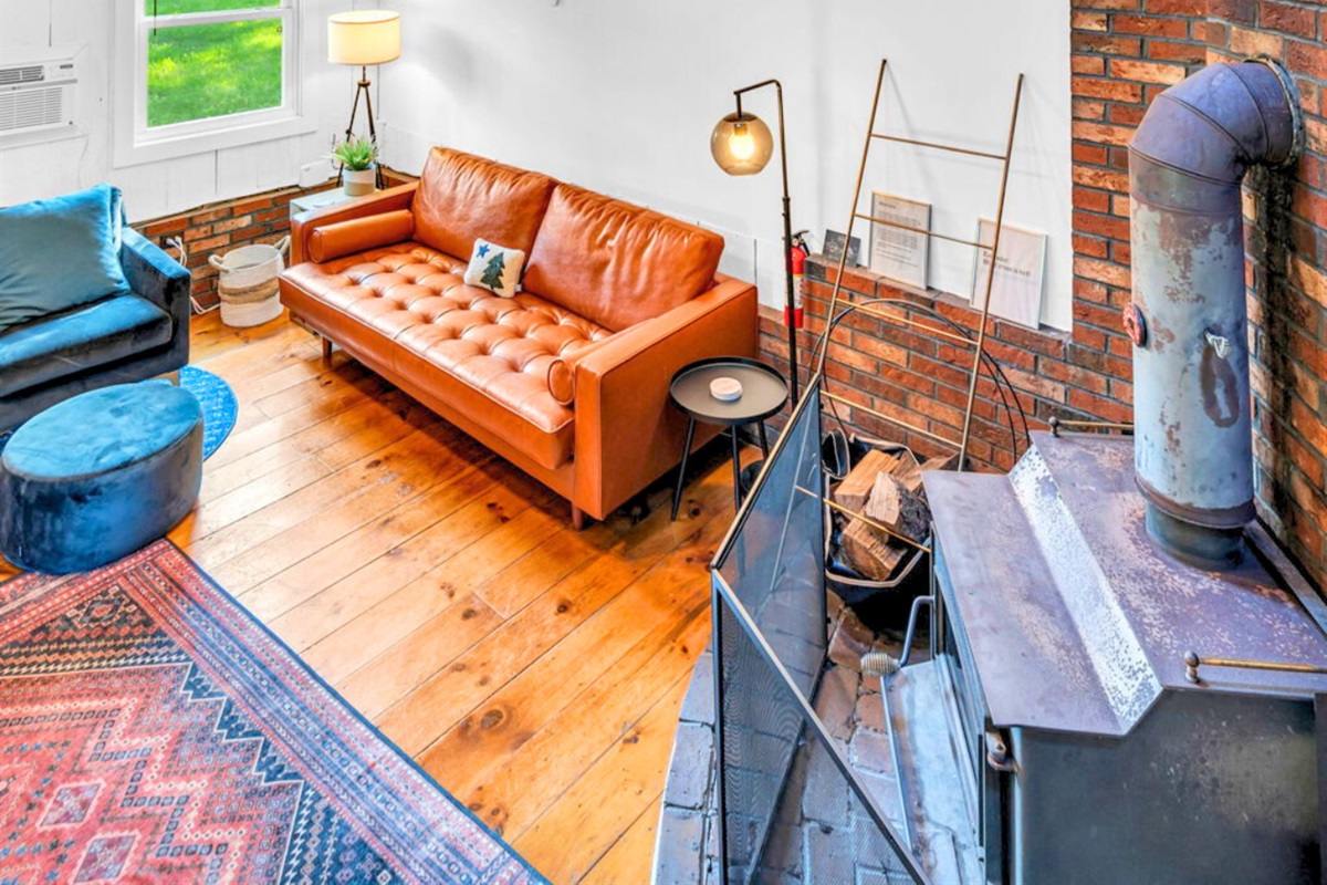 Get cozy on our comfortable leather couch and embrace the warmth of the inviting fireplace. Relax, unwind, and make lasting memories in this perfect retreat for ultimate comfort!