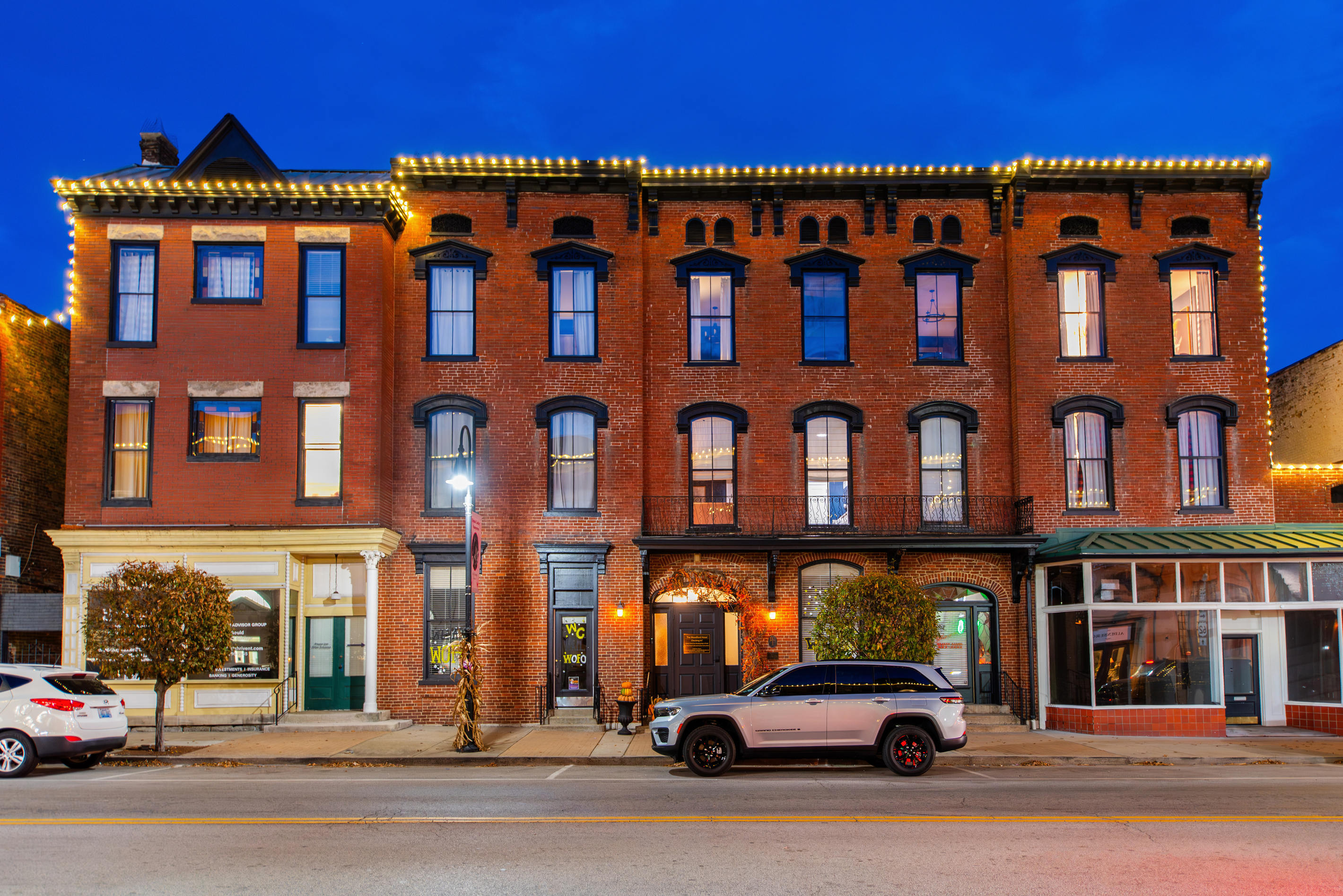 The Woodford Hotel at night, with lights outlining the roof.