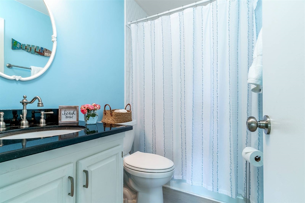 The second full bath has a tub/shower combo, dark granite vanity, and coastal touches. Two bathrooms for 6 guests makes all the difference.