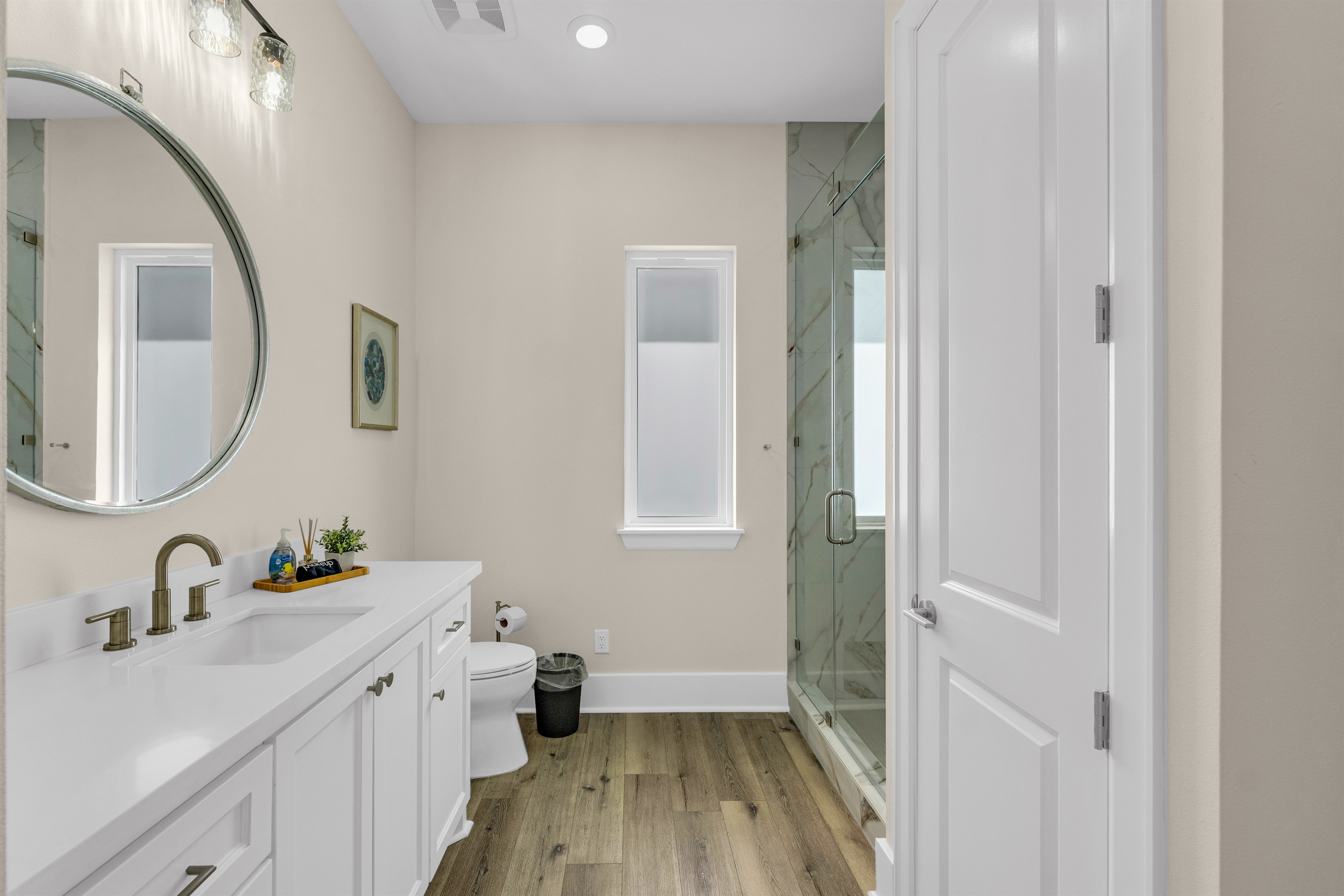 Costa Cristal Bathroom 5 Ensuite: View from the entry showcasing the bright white bathroom with a round mirror, giving a clear first impression of the clean and inviting space.