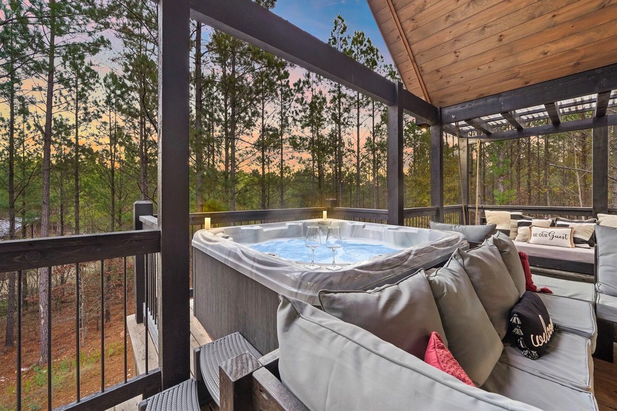 Covered lounge area with cozy seating and hot tub access.