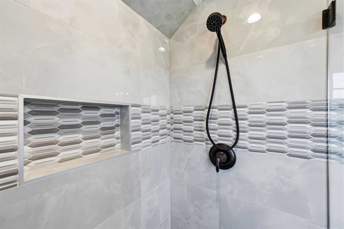 Spacious glass walk-in shower with elegant tile accents and a spa-like feel, perfect for unwinding after a beach day