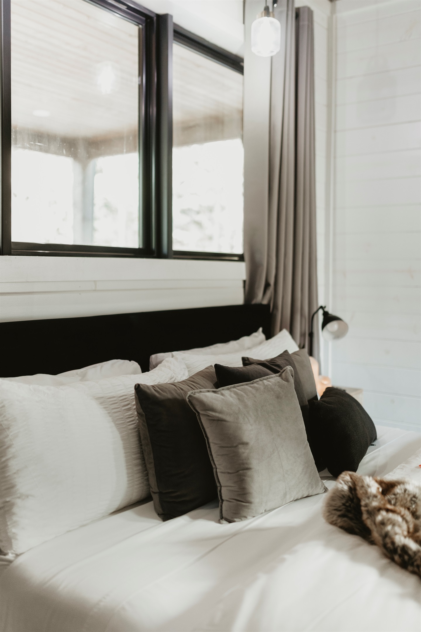 Soft textures and layered pillows create a cozy, inviting bedroom retreat. Perfect for sinking in after a day of adventure and waking up refreshed for peaceful mornings in the pines.