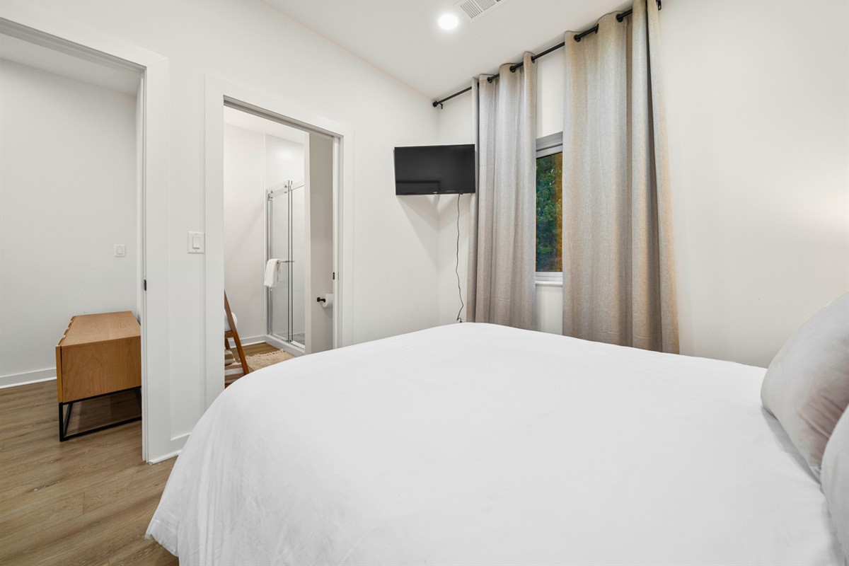 Peaceful queen bedroom with ensuite access and warm, natural light.