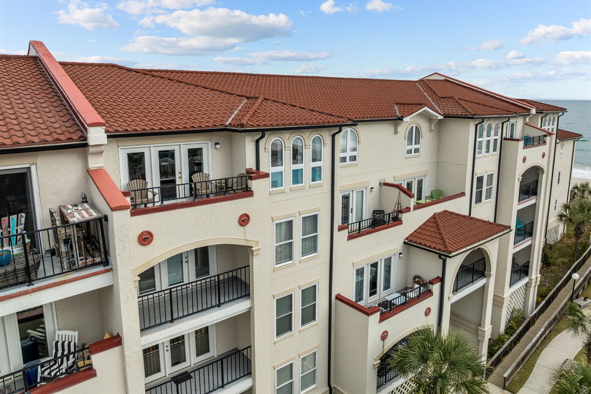 Beautiful Mediterranean-style exterior with private balconies just steps from the ocean