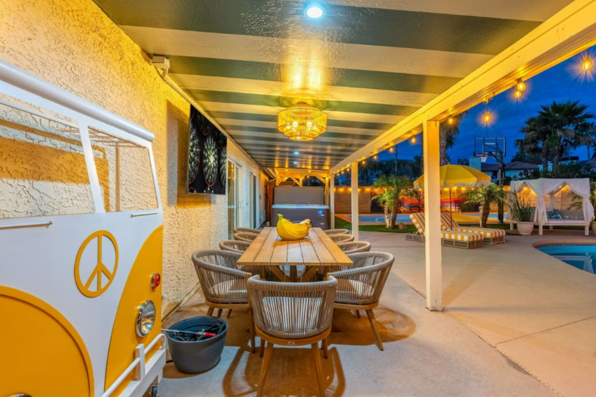 Covered patio with dining table, rattan chairs, and ambient lighting—ideal for evening gatherings and poolside entertaining.