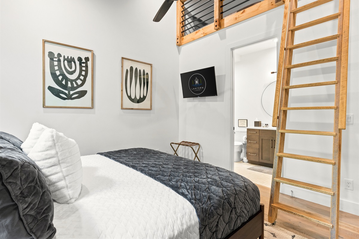 It is a cozy loft-style bedroom with simple decor, providing additional sleeping arrangement on the second level.
