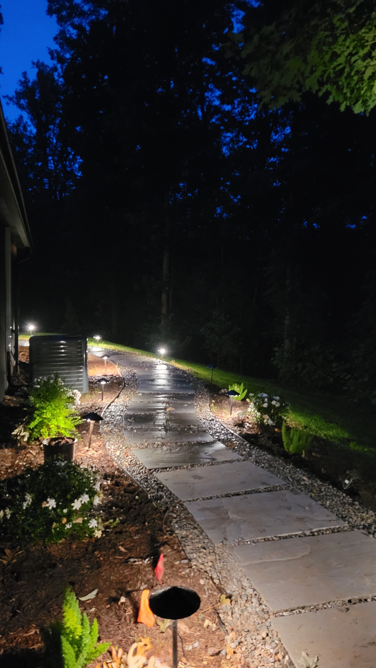 Landscape lights light the way to the hot tub patio, evening view
