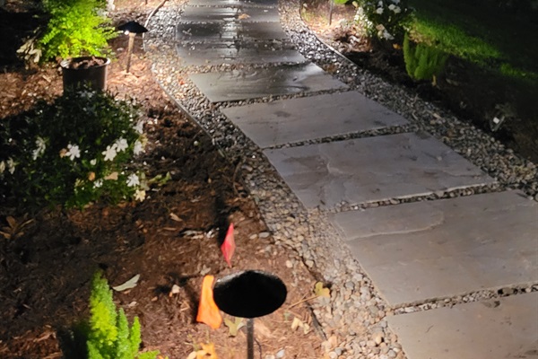 Landscape lights light the way to the hot tub patio, evening view