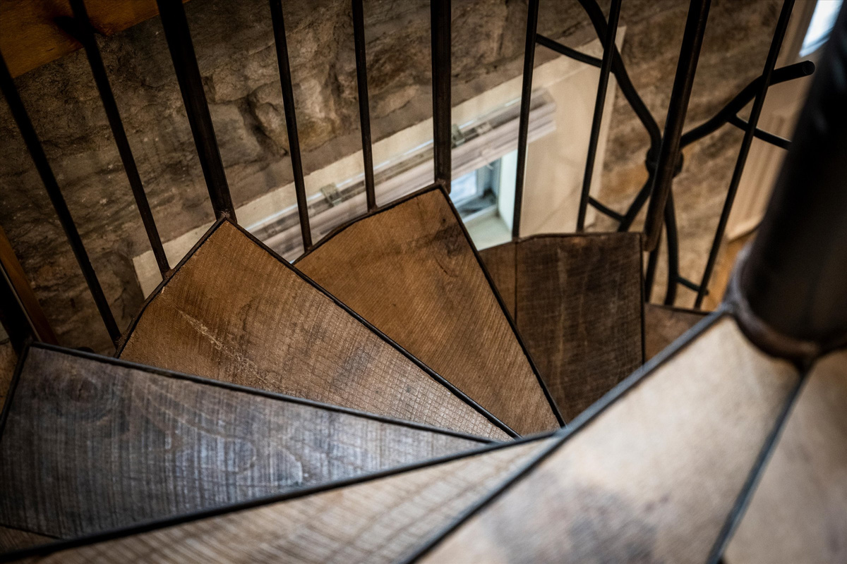 Spiral Stairs to go to the lower level where King Bed and desk are located.