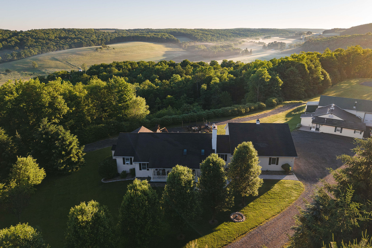 🌄 Hilltop seclusion — the farmhouse framed by forest.