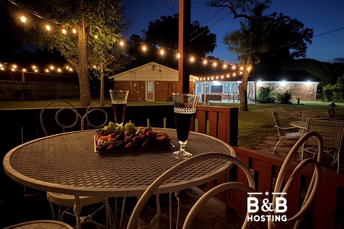 Your private outdoor paradise awaits with multiple entertainment areas, mature shade trees, and magical string lighting for perfect evening gatherings.