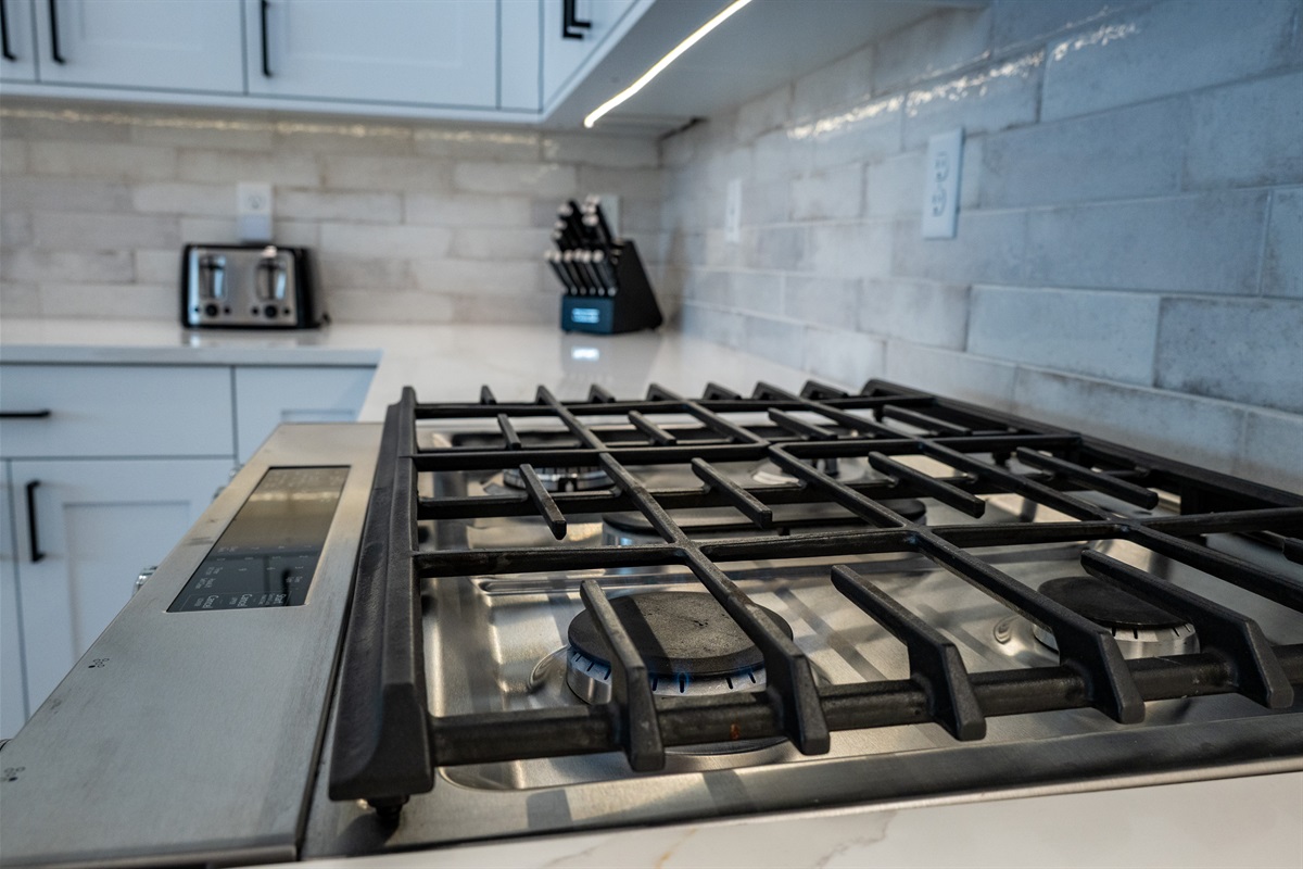 Gas cooktop with modern backsplash — perfect for preparing meals after a day on the slopes.