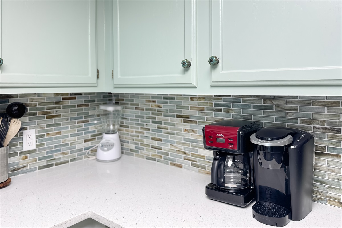 Enjoy your morning brew with both a traditional coffee pot and a single-serve machine, complemented by essential countertop appliances in this well-equipped kitchen.