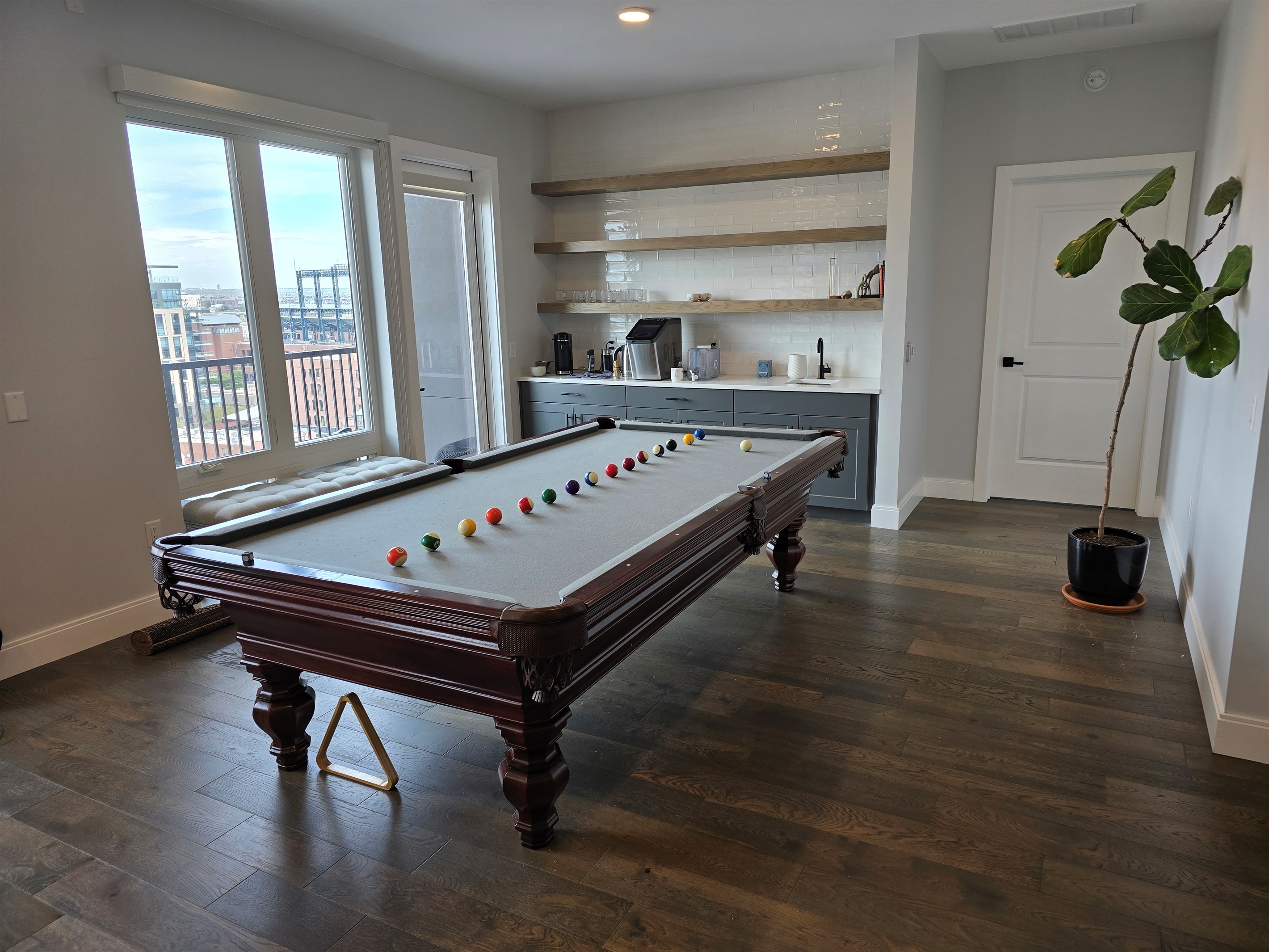 🎱 Living room with custom 9ft pool table, 85" Smart TV, and balcony views.